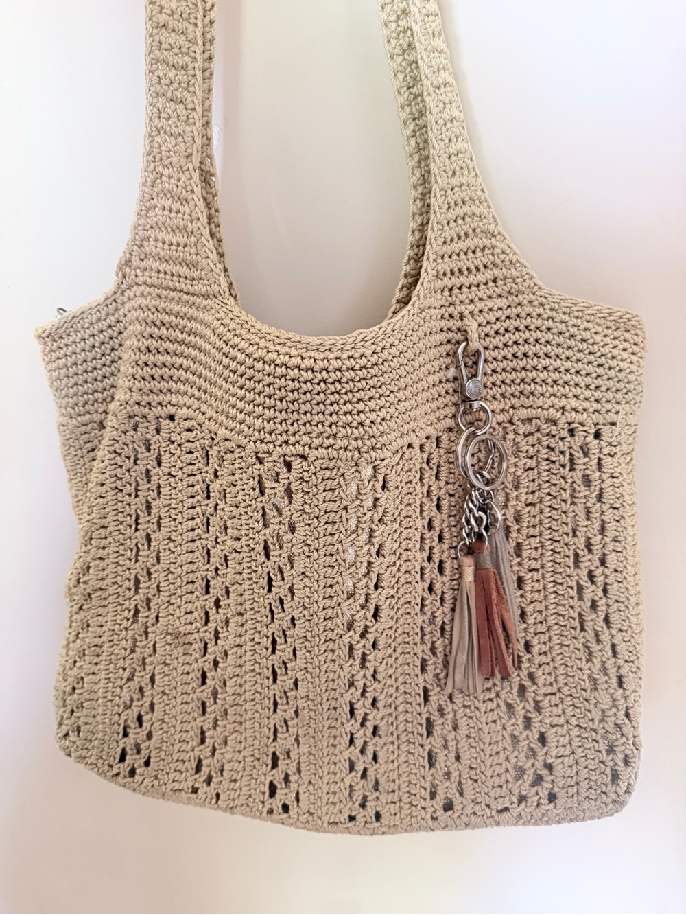 The Sak Beige Crochet Shoulder Tote Bag with Matching Decorative Tassel Charm